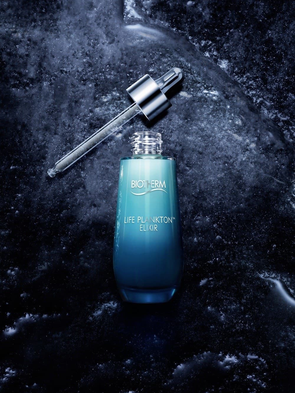 Flacon Life Plankton Elixir et sa pipette sur une roche mouillée