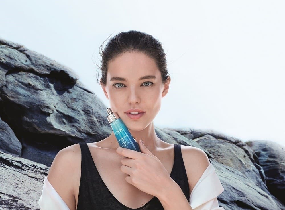 Emily DiDonato et le flacon Life Plankton Elixir devant des rochers
