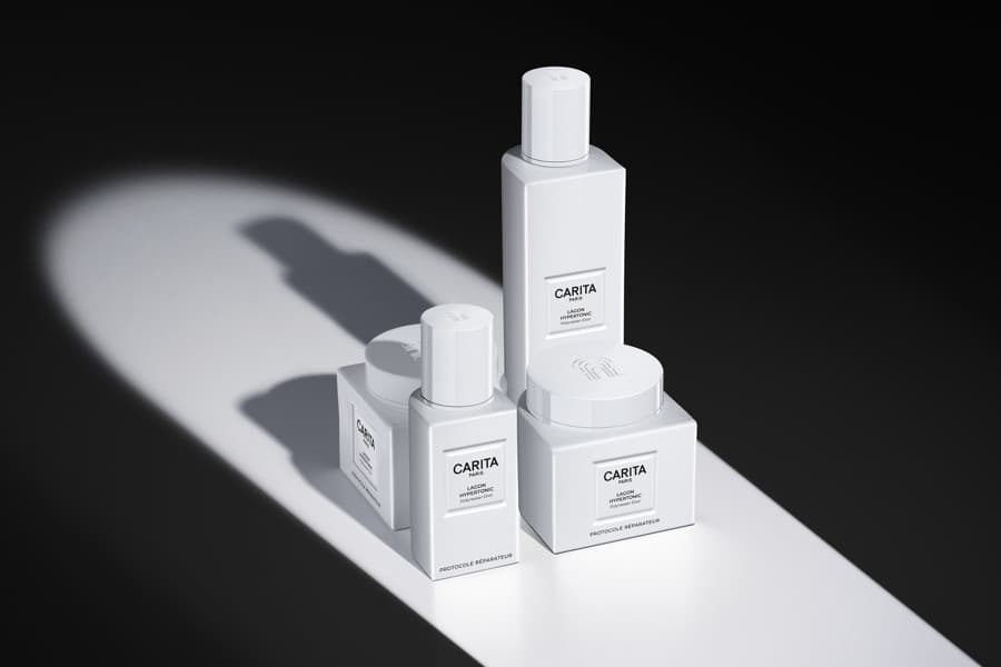 Gamme blanche Carita, flacons et pots sous un rayon de lumière