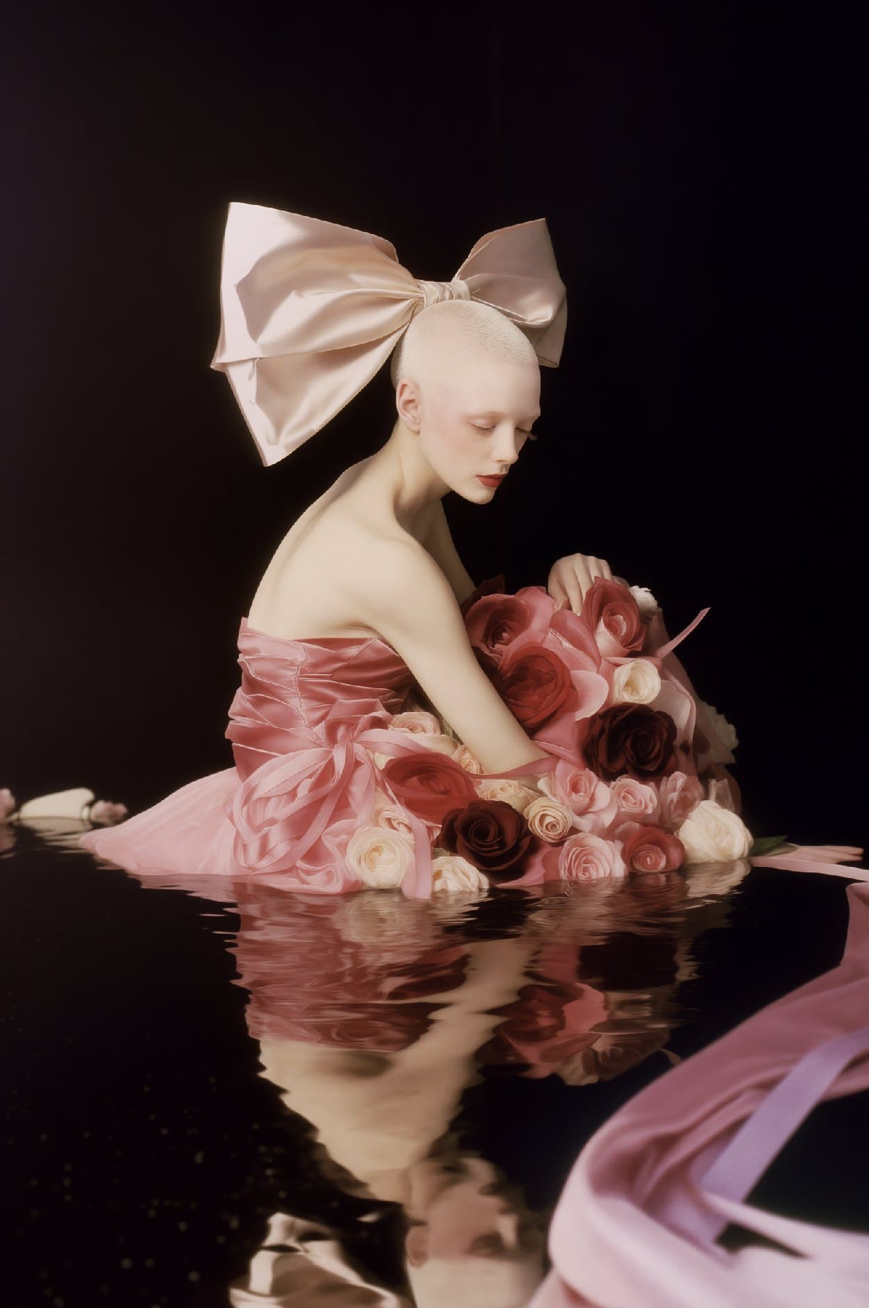 Femme au nœud de satin rose parmi les roses