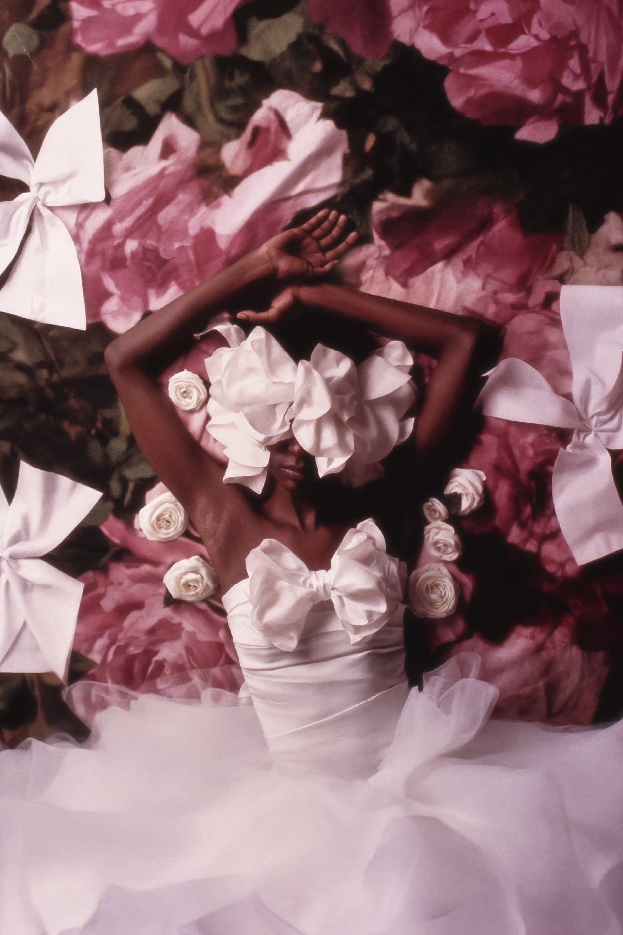 Femme parée de nœuds blancs parmi les fleurs roses