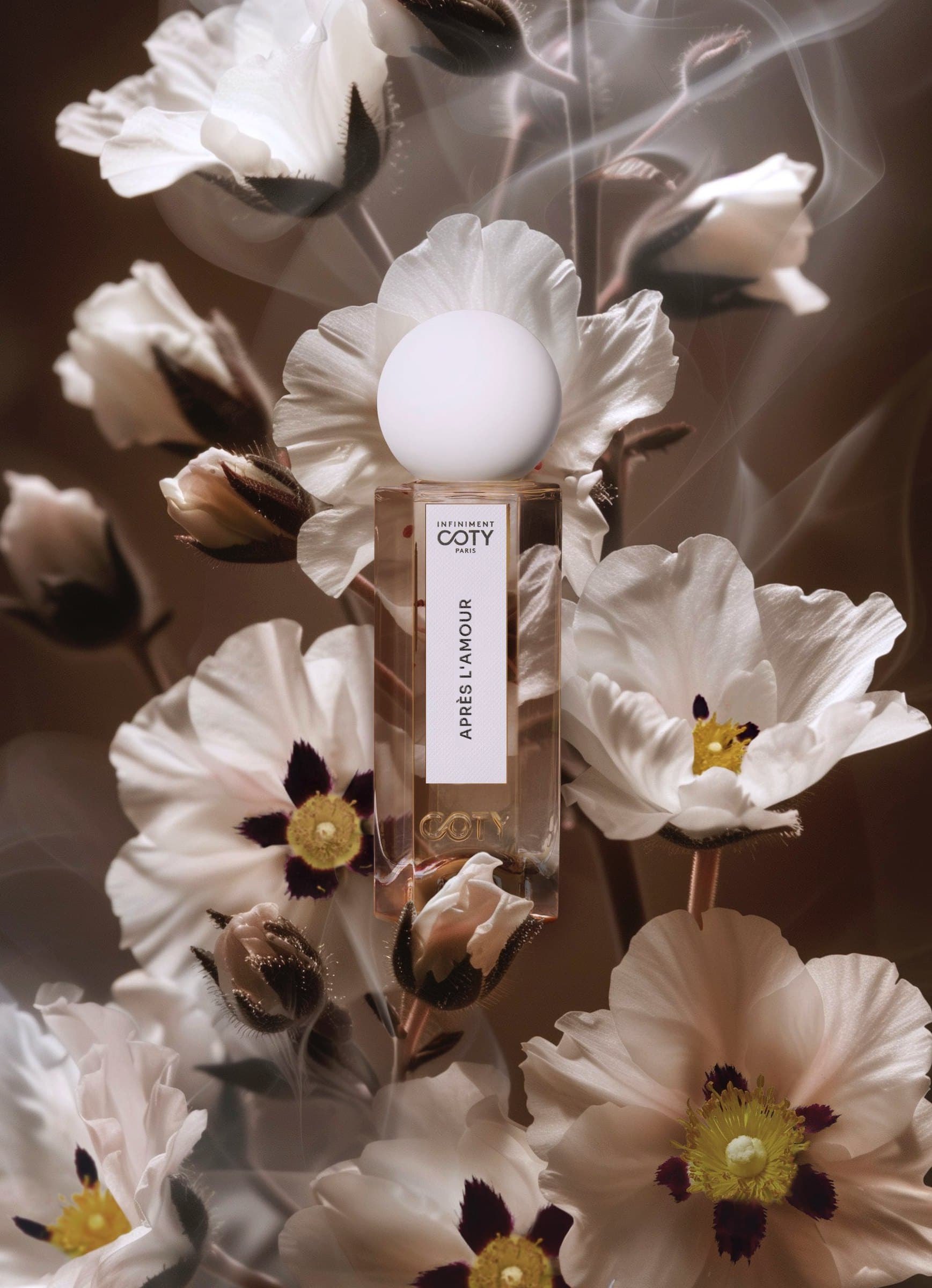 Flacon Après l'amour entre fleurs blanches et fumée