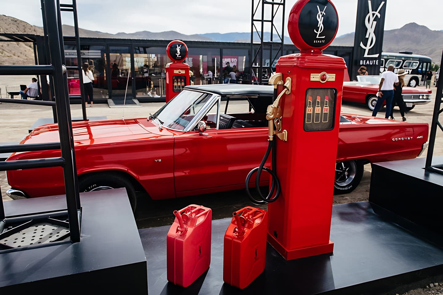Voiture rouge et pompe à essence YSL, jerricans rouges