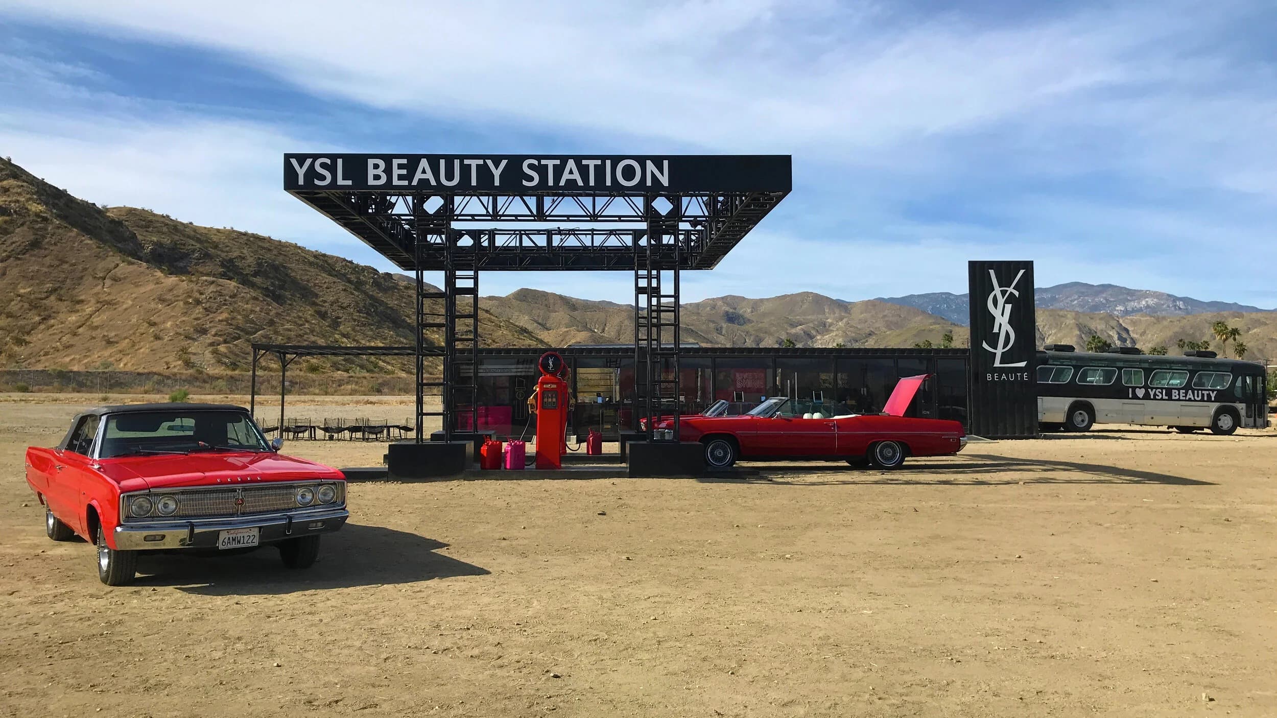 La YSL Beauty Station dans le désert, voitures rouges et enseigne YSL